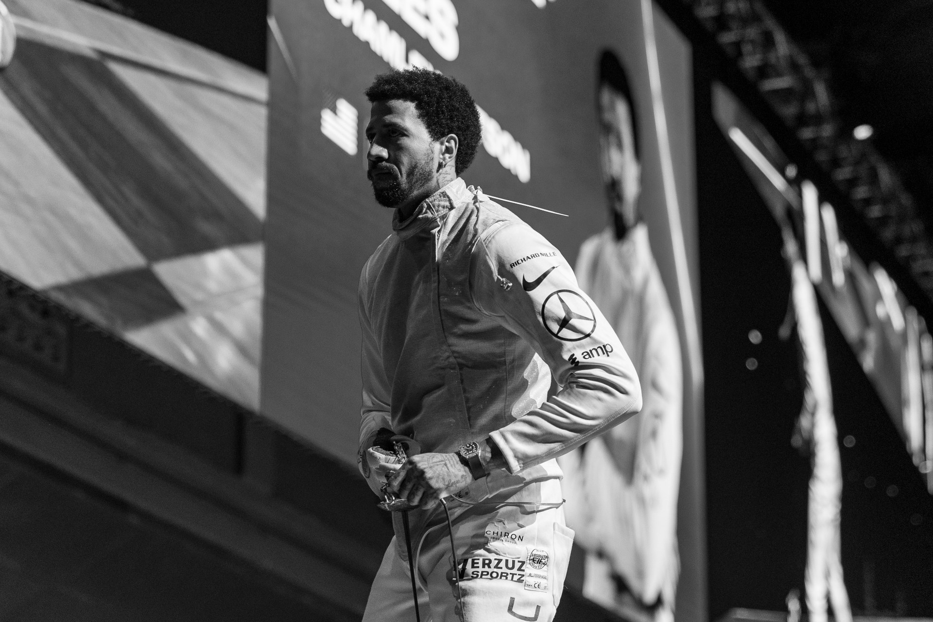 A Blade Collective athlete walks off the piste, sponsor logos visible on the jacket.